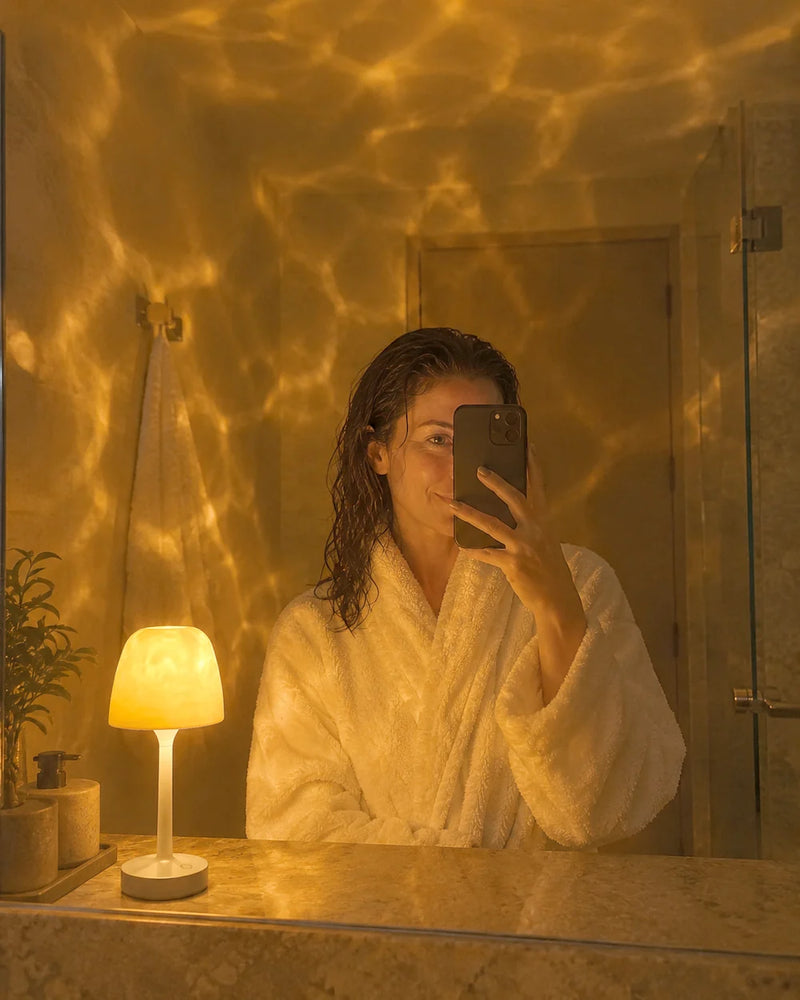 Cliente en peignoir, selfie dans le miroir à côté de sa lampe Aurora
